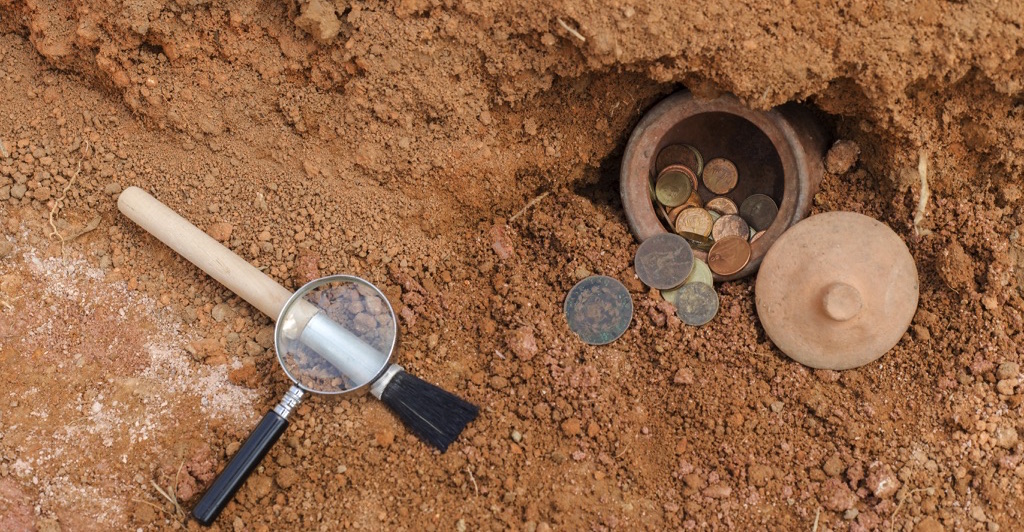 Tierra, monedas y lupa para geología