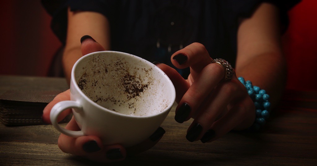 Mujer con una taza de té, tratando de predecir su futuro