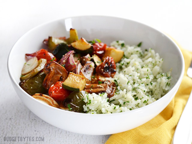 Tazón lleno con champiñones, pimiento verde, calabacita, tomates, cebolla morada y arroz blanco