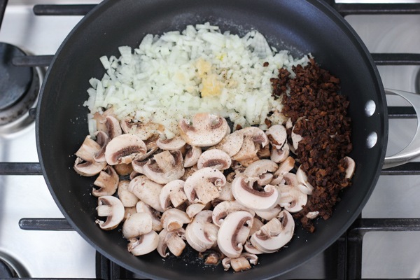 A ese mismo sartén le añadirás 2 cucharaditas de aceite y la cebolla picada, los champiñones frescos, los hongos porcinos deshidratados y el ajo picado y después lo condimentas con sal y pimienta.