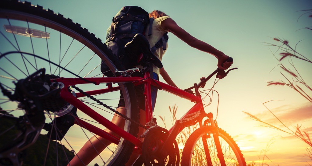 Mujer con mochila junta a su bicicleta