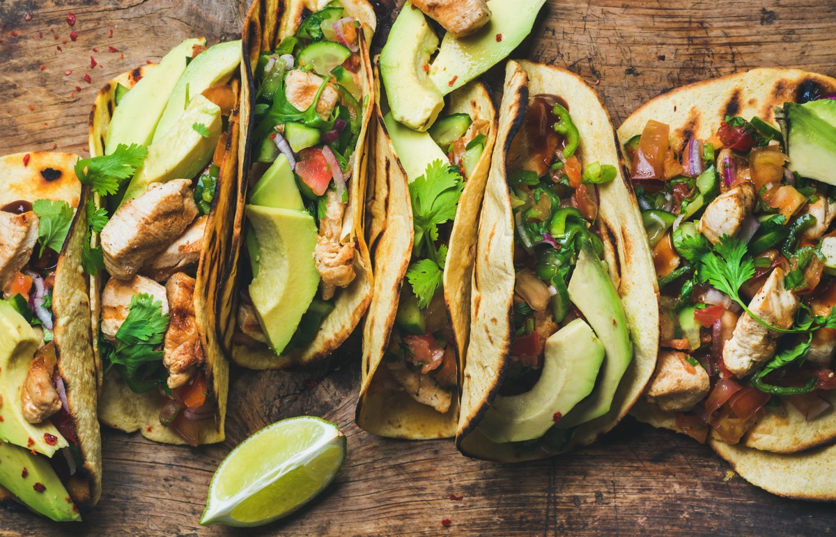 Tacos de maíz rellenos con cilantro, pechuga de pollo, aguacate  y salsa